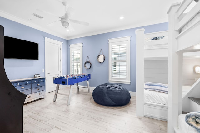 bedroom featuring visible vents, light wood-style flooring, ornamental molding, ceiling fan, and baseboards