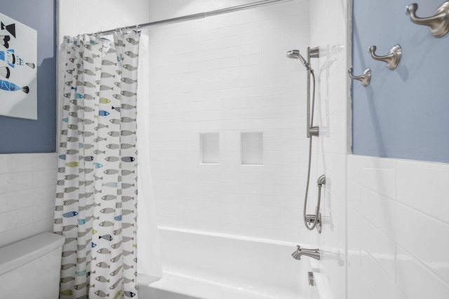 bathroom with shower / bathtub combination with curtain, wainscoting, tile walls, and toilet