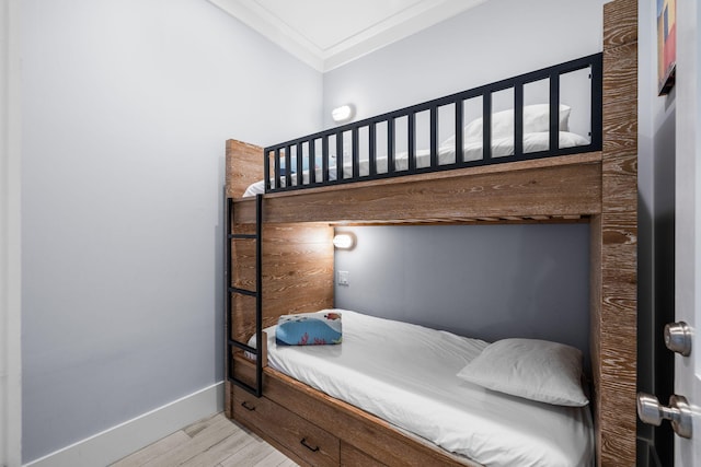 bedroom with baseboards, wood finished floors, and crown molding