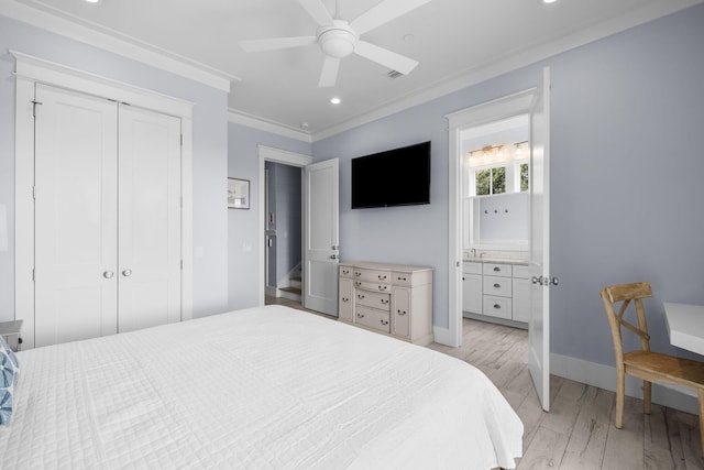 bedroom featuring crown molding, a closet, light wood-style flooring, ensuite bath, and baseboards