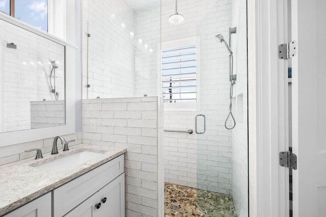 full bathroom with a shower stall and vanity