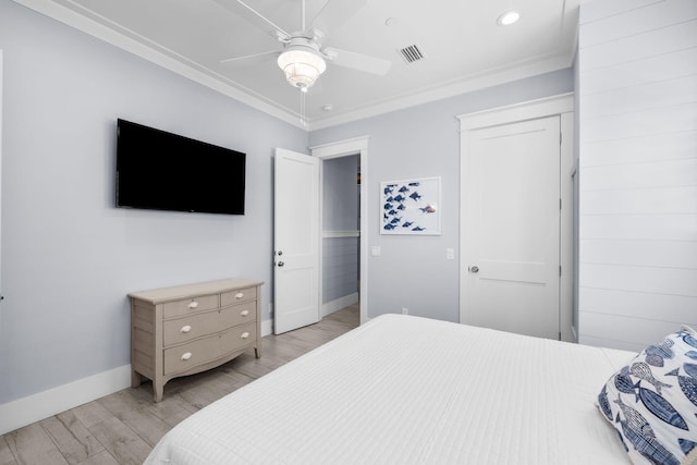 bedroom featuring a closet, visible vents, crown molding, and light wood-style flooring