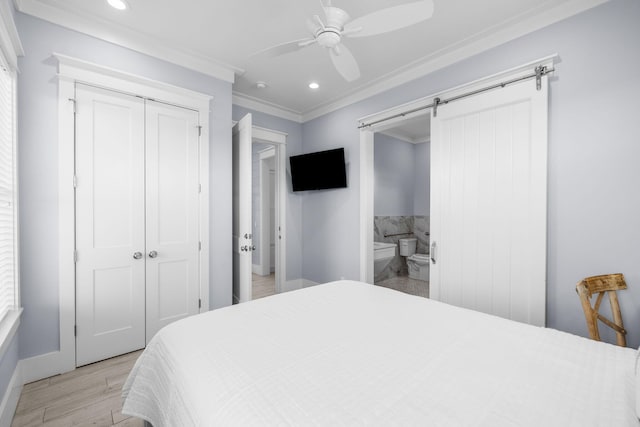 bedroom with a barn door, ornamental molding, light wood-style floors, a closet, and recessed lighting