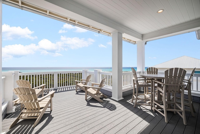 wooden deck with a water view and a view of the beach