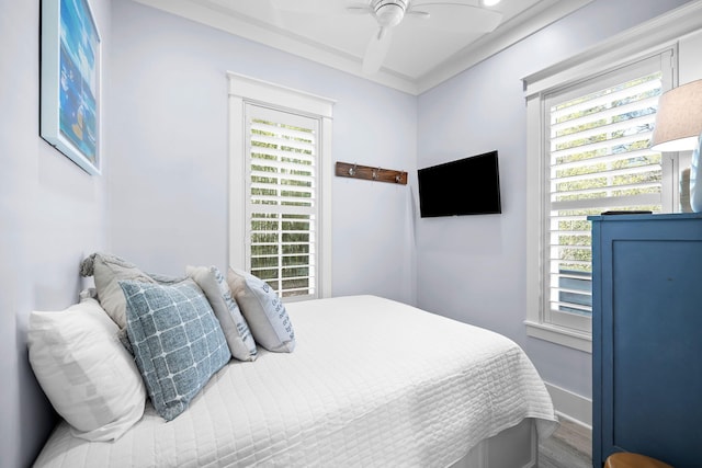 bedroom featuring ceiling fan, baseboards, and wood finished floors