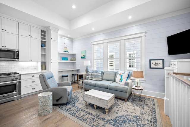 living area featuring light wood-type flooring, baseboards, and recessed lighting