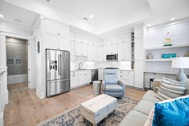 living area featuring light wood-type flooring, visible vents, a tray ceiling, and recessed lighting