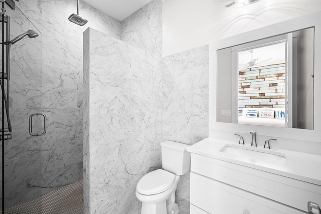 full bath featuring toilet, a marble finish shower, tile walls, and vanity