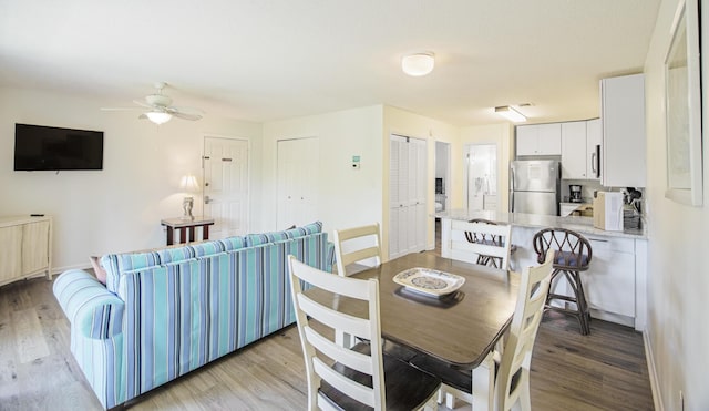 dining room featuring light wood-style floors and a ceiling fan