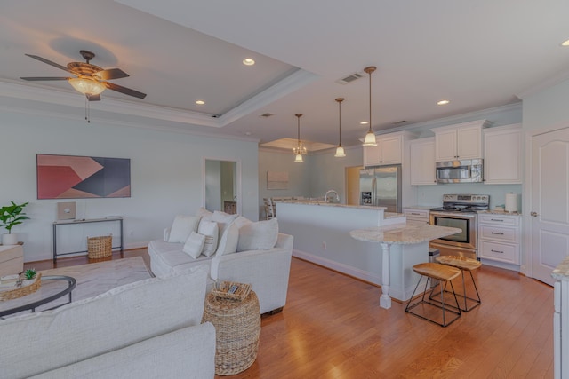 kitchen featuring visible vents, light wood-style floors, open floor plan, appliances with stainless steel finishes, and a kitchen bar