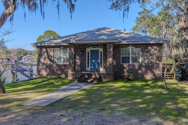 bungalow-style home with brick siding and a front lawn