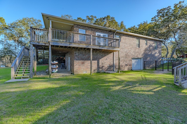 back of property with stairway, a deck, a lawn, and brick siding