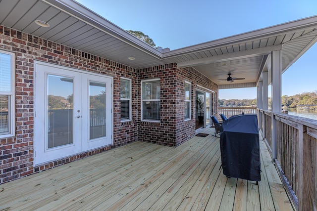 wooden terrace featuring a ceiling fan, french doors, a water view, and a grill