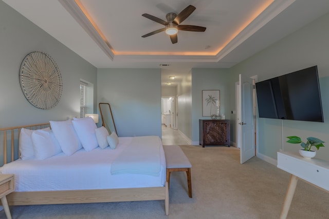 bedroom with baseboards, a raised ceiling, a ceiling fan, and light colored carpet