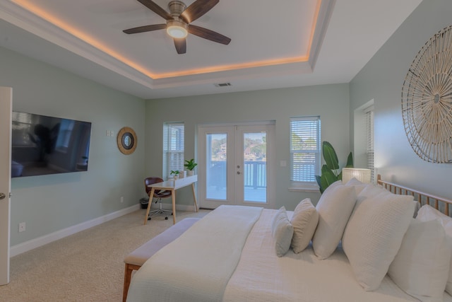 carpeted bedroom featuring access to exterior, visible vents, a tray ceiling, and french doors