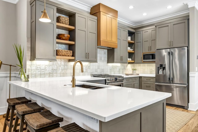 kitchen with open shelves, stainless steel appliances, gray cabinets, a sink, and a peninsula