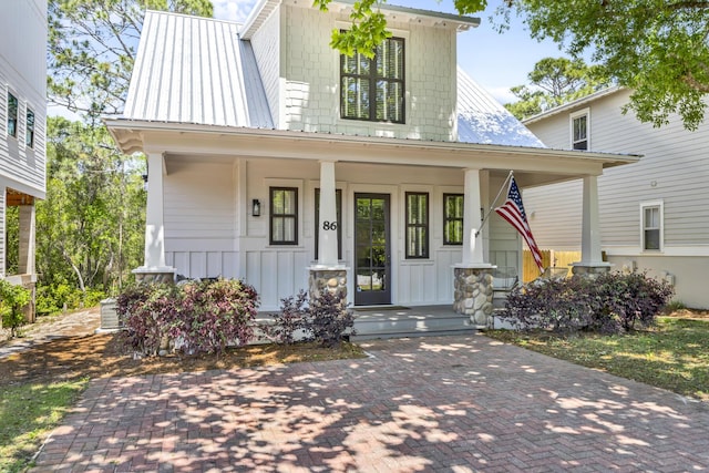 view of front of property featuring metal roof, a porch, and board and batten siding