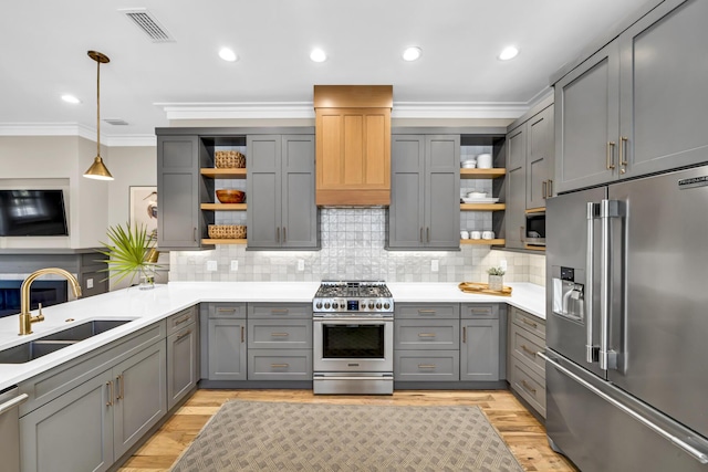 kitchen with stainless steel appliances, gray cabinetry, premium range hood, open shelves, and a sink