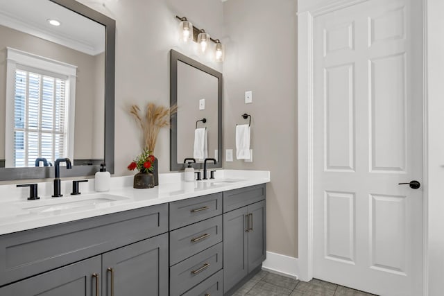 full bathroom with ornamental molding, a sink, baseboards, and double vanity