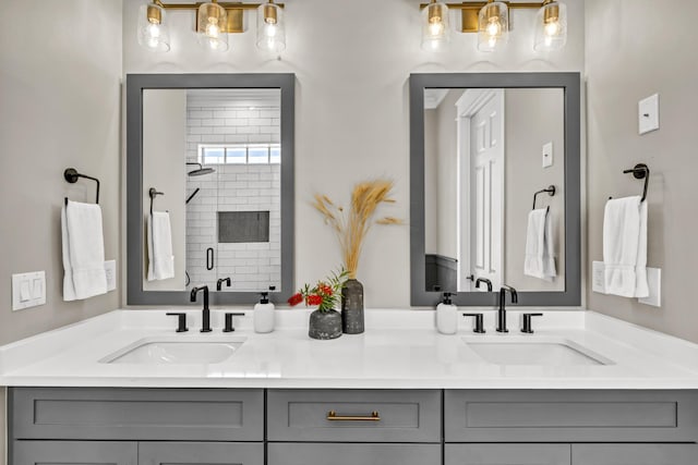 bathroom with a sink, a shower stall, and double vanity