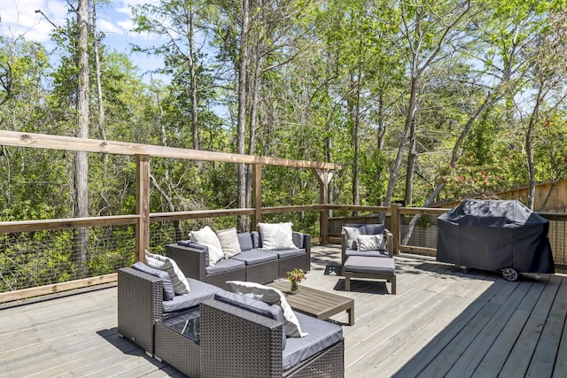 wooden deck with an outdoor hangout area, a grill, and fence