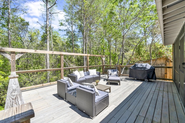 wooden deck with an outdoor living space and area for grilling