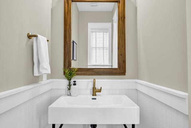 bathroom with a wainscoted wall and a sink