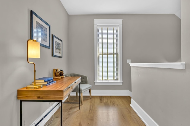 office space featuring vaulted ceiling, wood finished floors, and baseboards