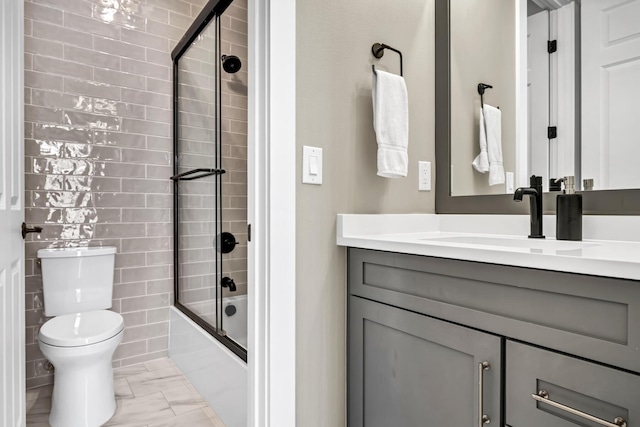 full bath featuring toilet, bath / shower combo with glass door, and vanity