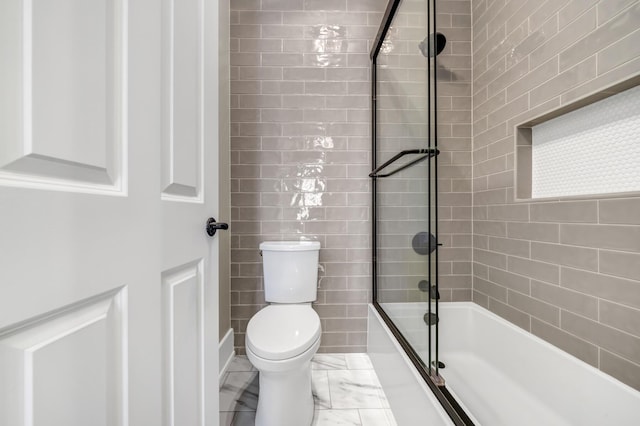 bathroom with toilet, marble finish floor, and washtub / shower combination