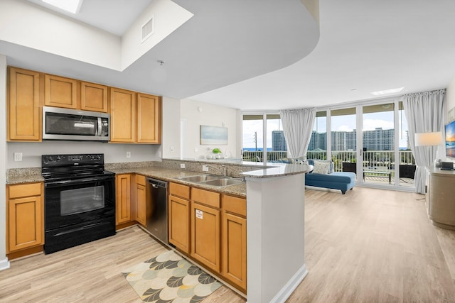 kitchen with visible vents, open floor plan, a peninsula, stainless steel appliances, and light wood-type flooring