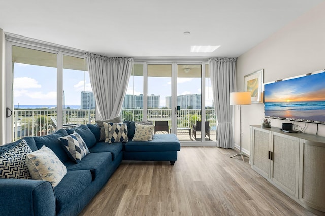 living area featuring a wealth of natural light, light wood-style flooring, and floor to ceiling windows