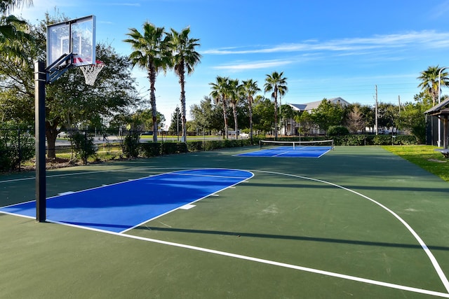 view of basketball court featuring community basketball court, fence, and a tennis court