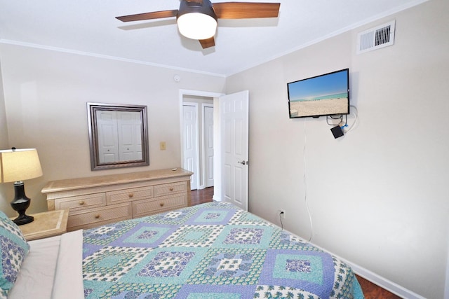 bedroom with a ceiling fan, visible vents, crown molding, and wood finished floors