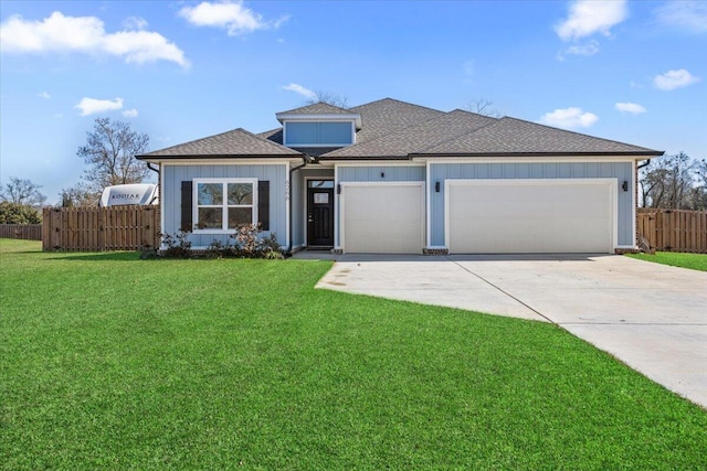 view of front of home featuring concrete driveway, an attached garage, fence, a front lawn, and board and batten siding