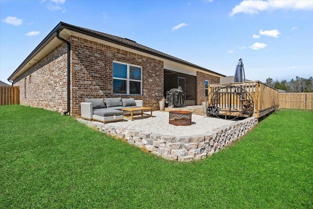 back of house with a patio, brick siding, fence, a lawn, and an outdoor living space with a fire pit