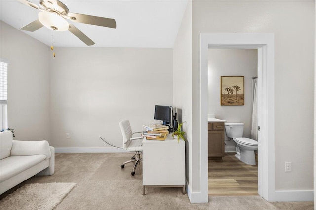 office with baseboards, a ceiling fan, and light colored carpet