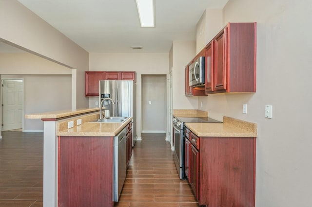 kitchen featuring wood finish floors, visible vents, appliances with stainless steel finishes, a sink, and dark brown cabinets