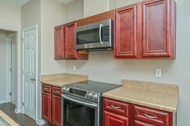 kitchen with stainless steel appliances, baseboards, light countertops, and dark brown cabinets