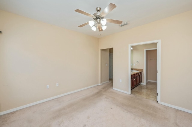 unfurnished bedroom featuring visible vents, a ceiling fan, light carpet, connected bathroom, and baseboards