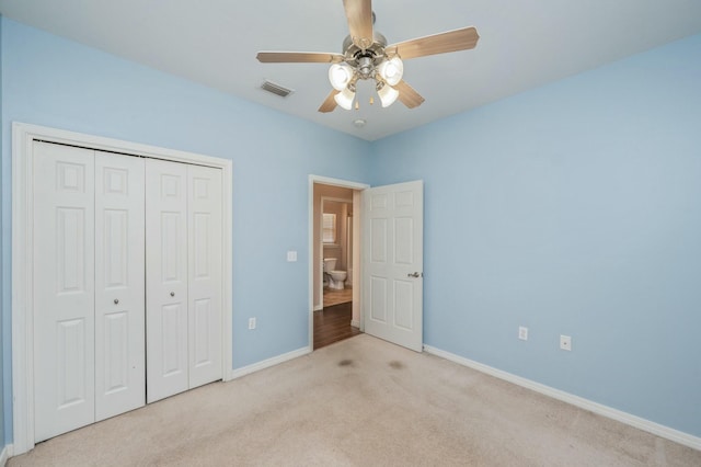 unfurnished bedroom featuring carpet floors, a closet, visible vents, and baseboards