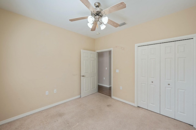 unfurnished bedroom with visible vents, baseboards, a ceiling fan, light colored carpet, and a closet