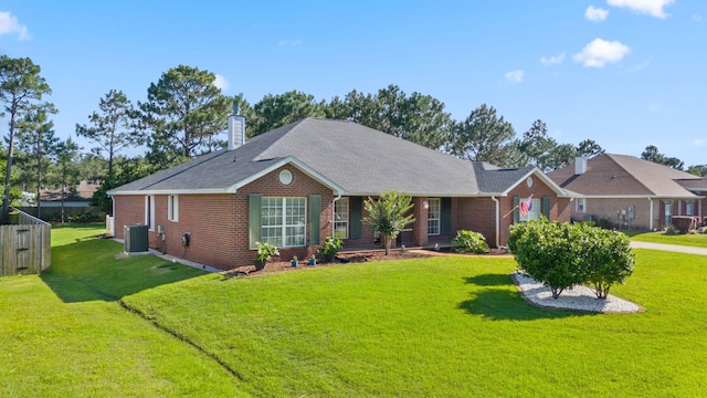 ranch-style home with brick siding, a chimney, a front yard, and central air condition unit