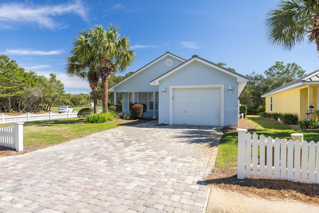 view of front facade with a garage, decorative driveway, fence, and stucco siding