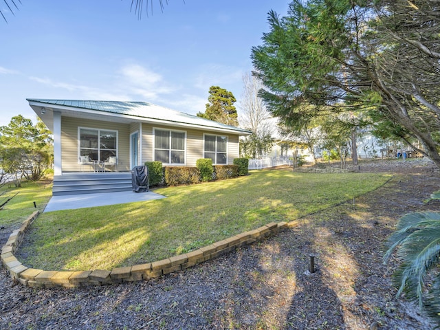 view of front of home with metal roof, a porch, and a front yard