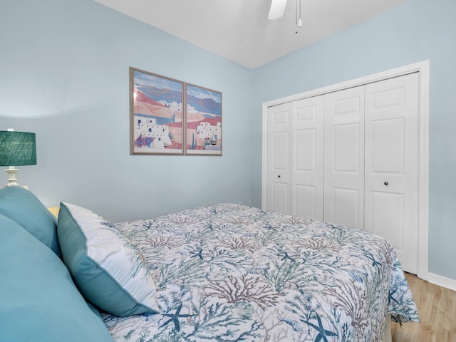 bedroom with ceiling fan, a closet, wood finished floors, and baseboards