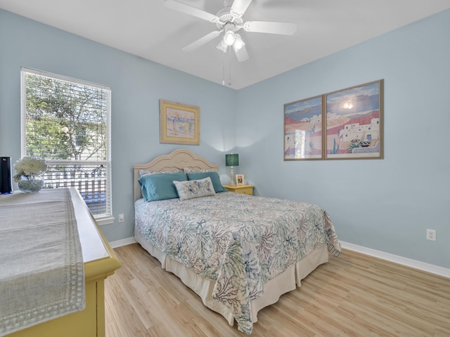 bedroom featuring a ceiling fan, baseboards, and wood finished floors