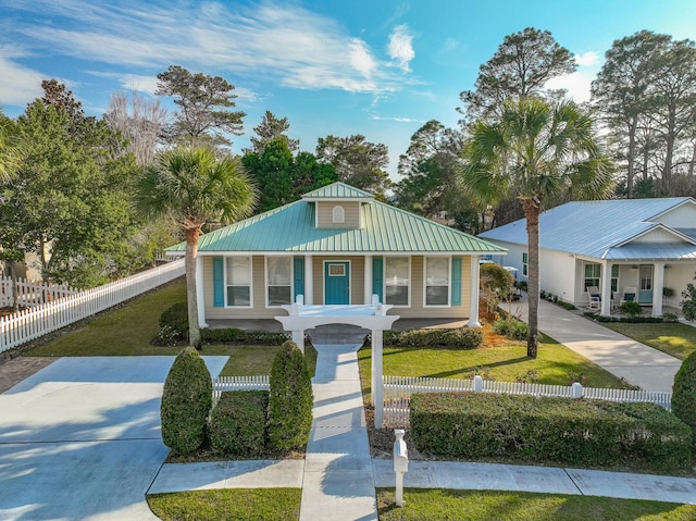 view of front of property featuring a fenced front yard, a front yard, and metal roof