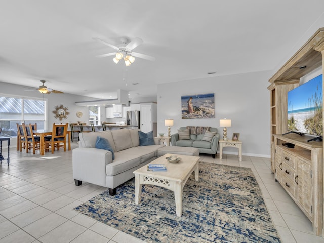 living room with light tile patterned floors, baseboards, and a ceiling fan