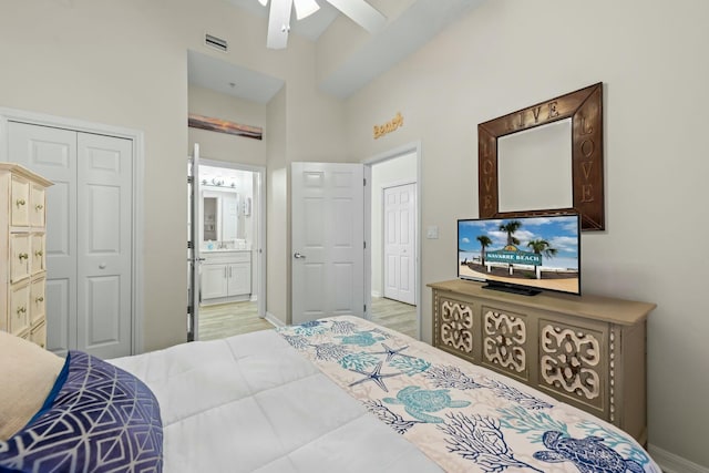 bedroom with ceiling fan, connected bathroom, light wood-style flooring, visible vents, and baseboards